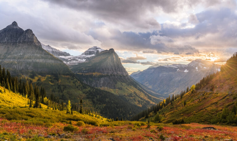 Sun sets over Heavens Peak in Glacier National Park, with Mt. Oberlin and Cannon Mountain