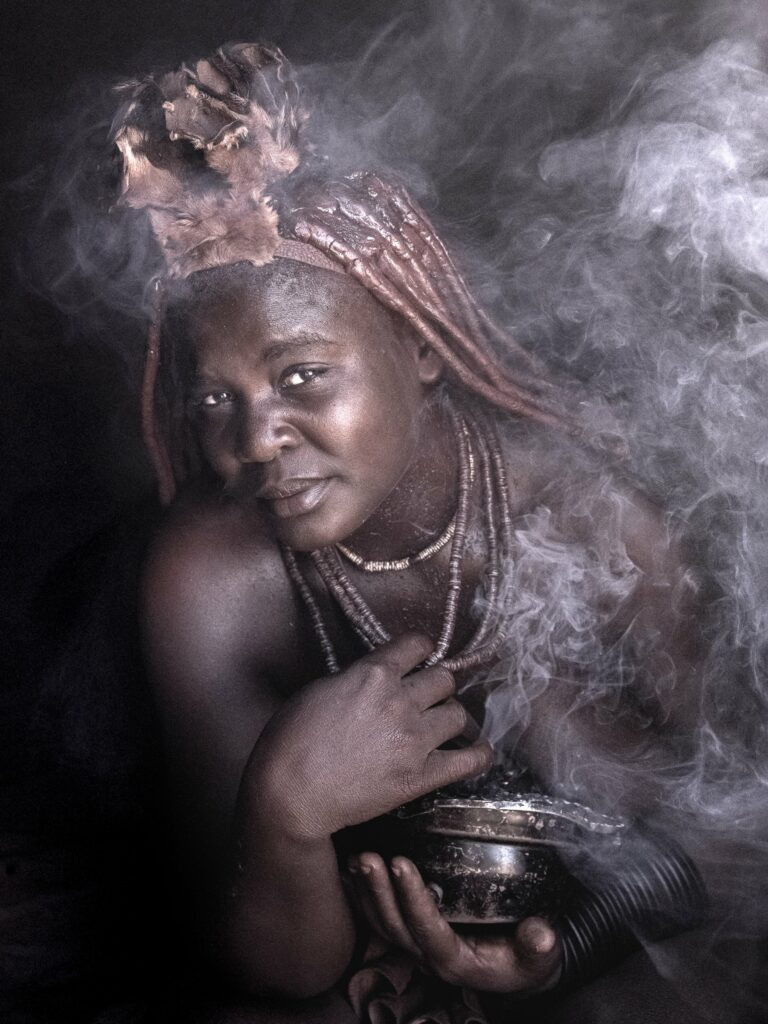 Himba woman taking a smoke bath in Namibia