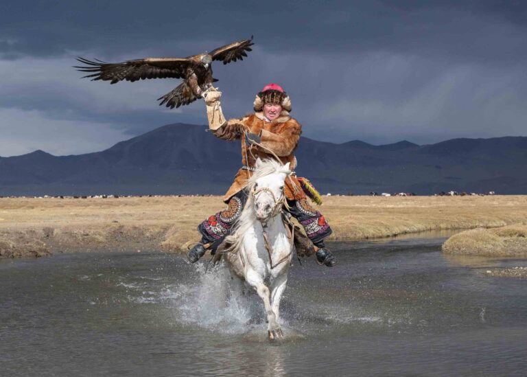 Eagle Hunter on white horse in river