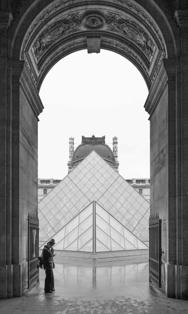 A woman waits out the rain at La Louvre